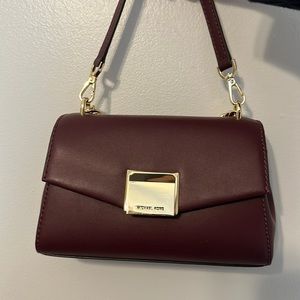Burgundy Michael Kors crossbody purse with gold